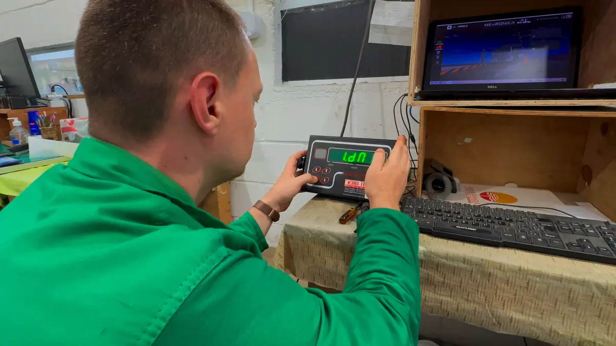 Técnico configurando indicador de pesagem integrado ao software da Metrônica